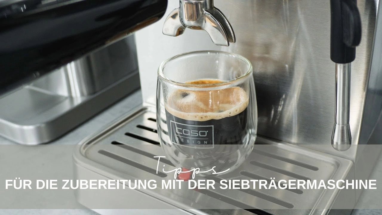 Espresso being made in an espresso machine. A glass of coffee is on the machine.