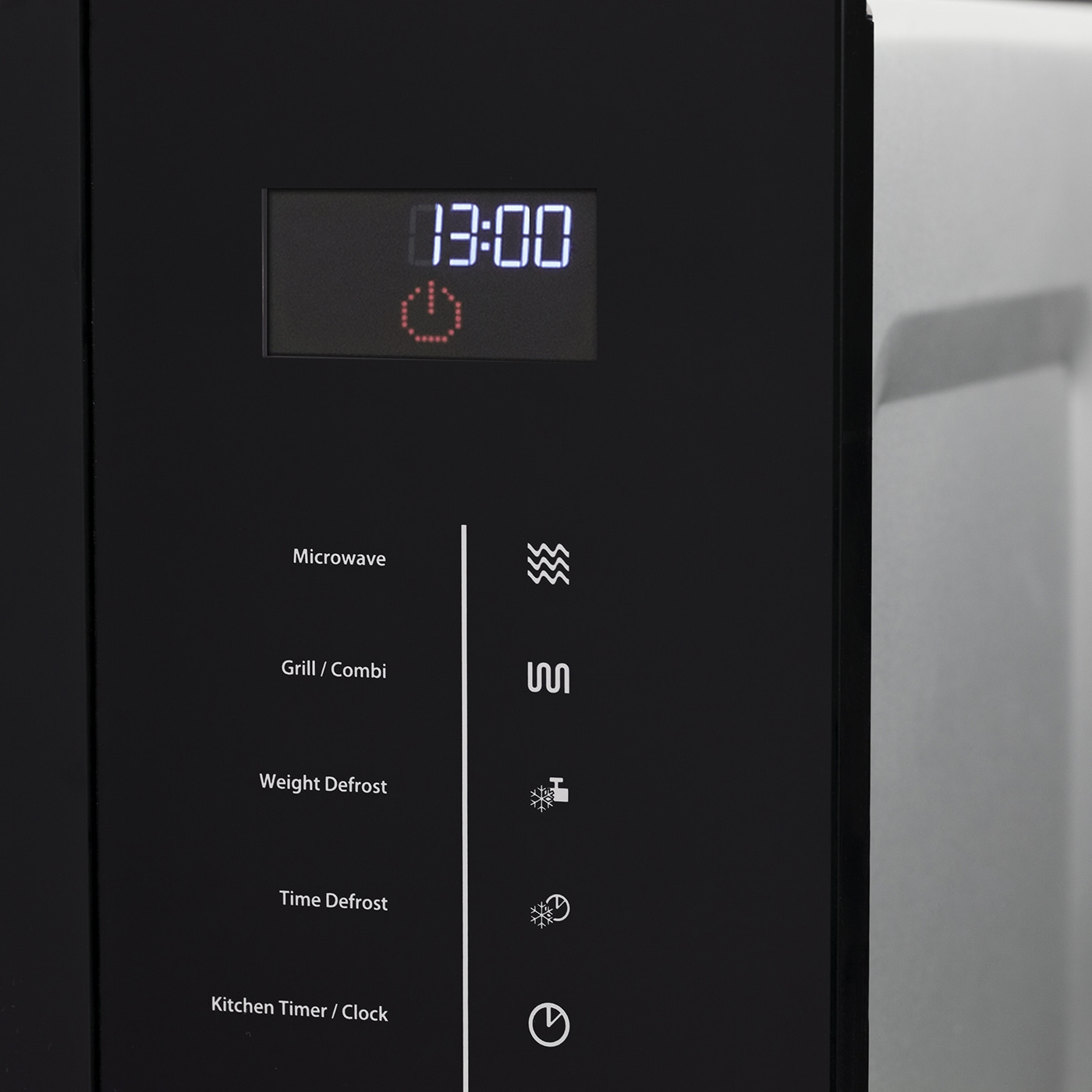 Microwave with control panel and digital display showing the time 13:00.