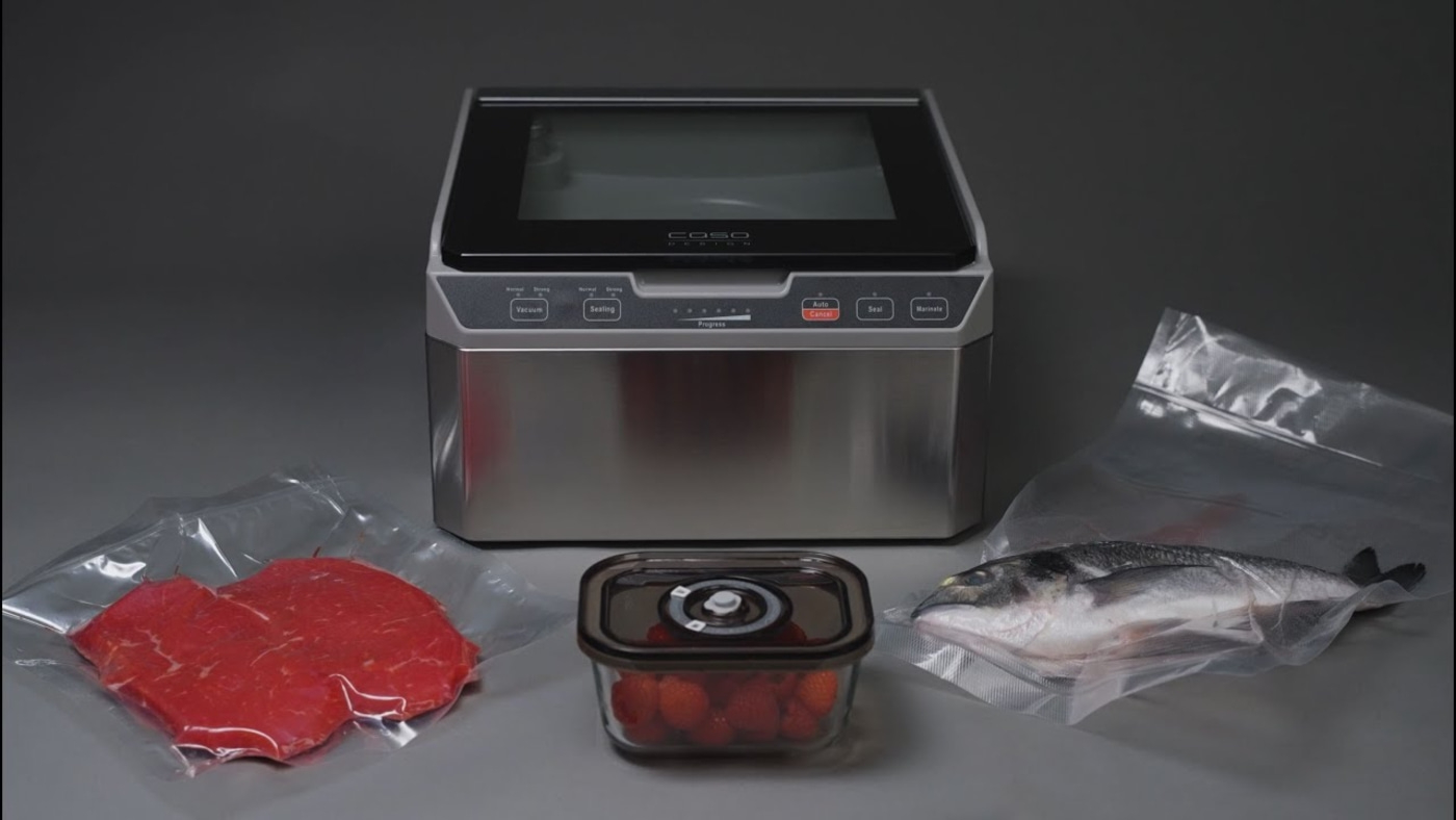 Vacuum sealer with meat, fish, and strawberries in bags and container