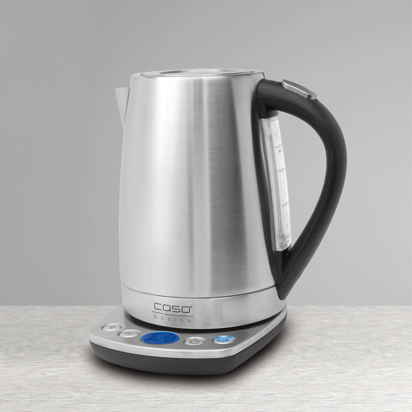 Stainless steel electric kettle with digital display and black handle on silver surface
