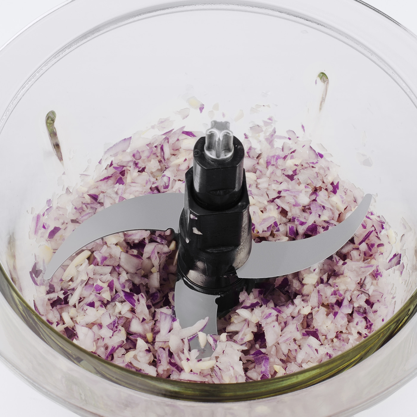 Chopped onions in a chopper with blades, close-up shot of the food.