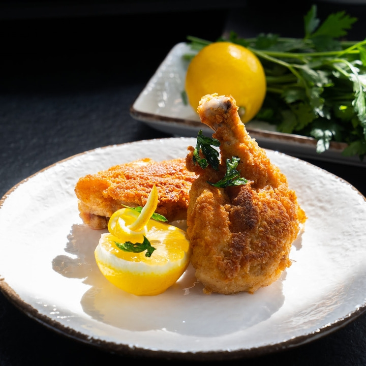 Fried chicken with lemon on a plate, close-up, food photography