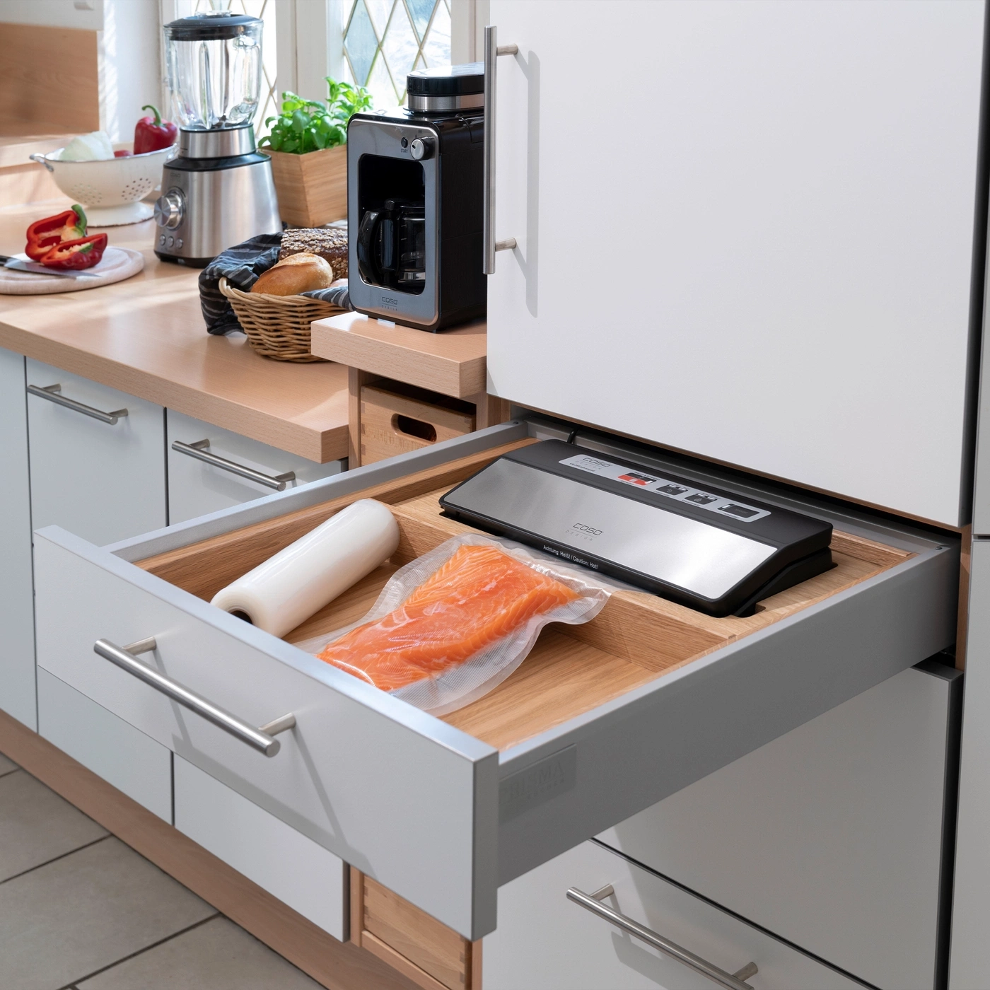 A drawer with a vacuum sealer and a piece of salmon.