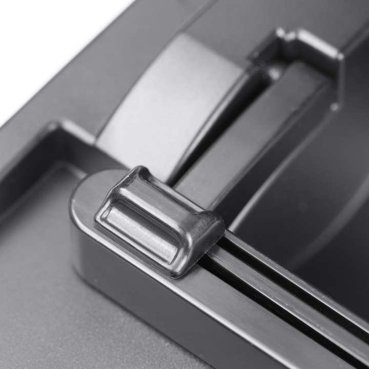 Close-up of a metal lever attached to a gray surface, with a shiny finish.
