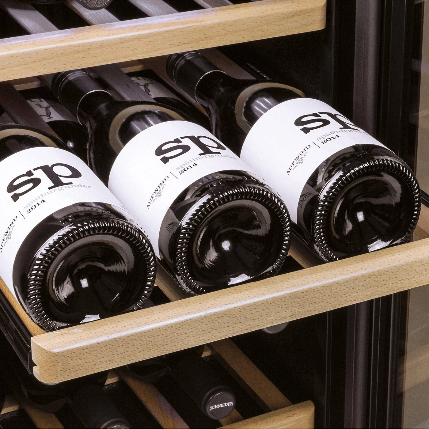 Wine bottles in a wine cooler, wooden shelves, labels with the inscription sp 2014