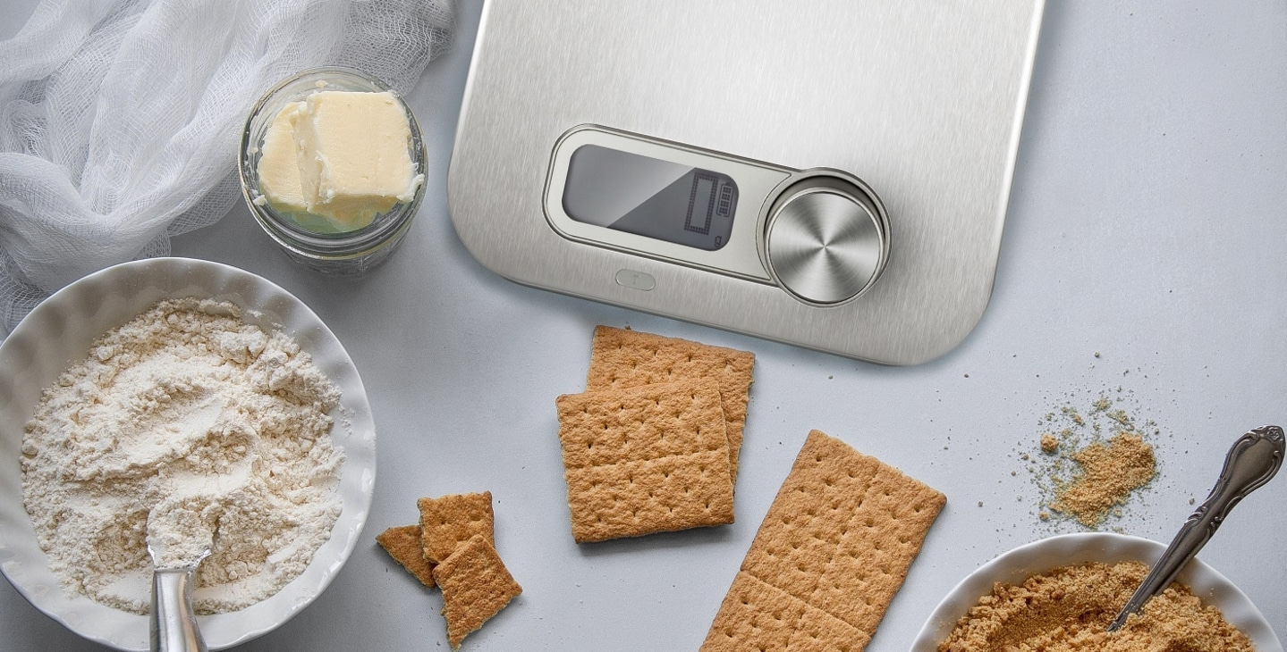 Ingredients for a cake: butter, flour, crackers, scale, bowl, spoon, food