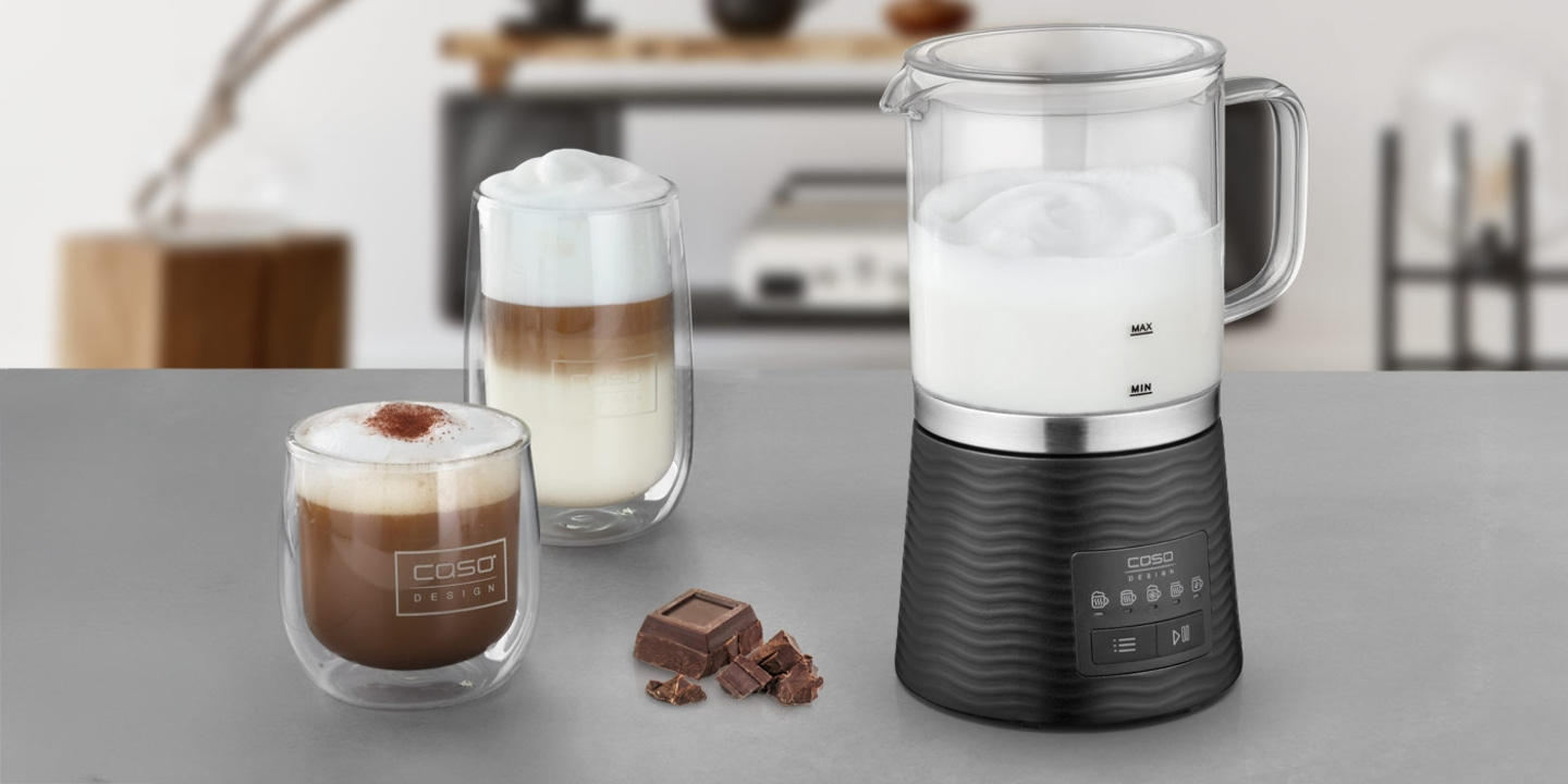 Milk frother with coffee and chocolate on the table