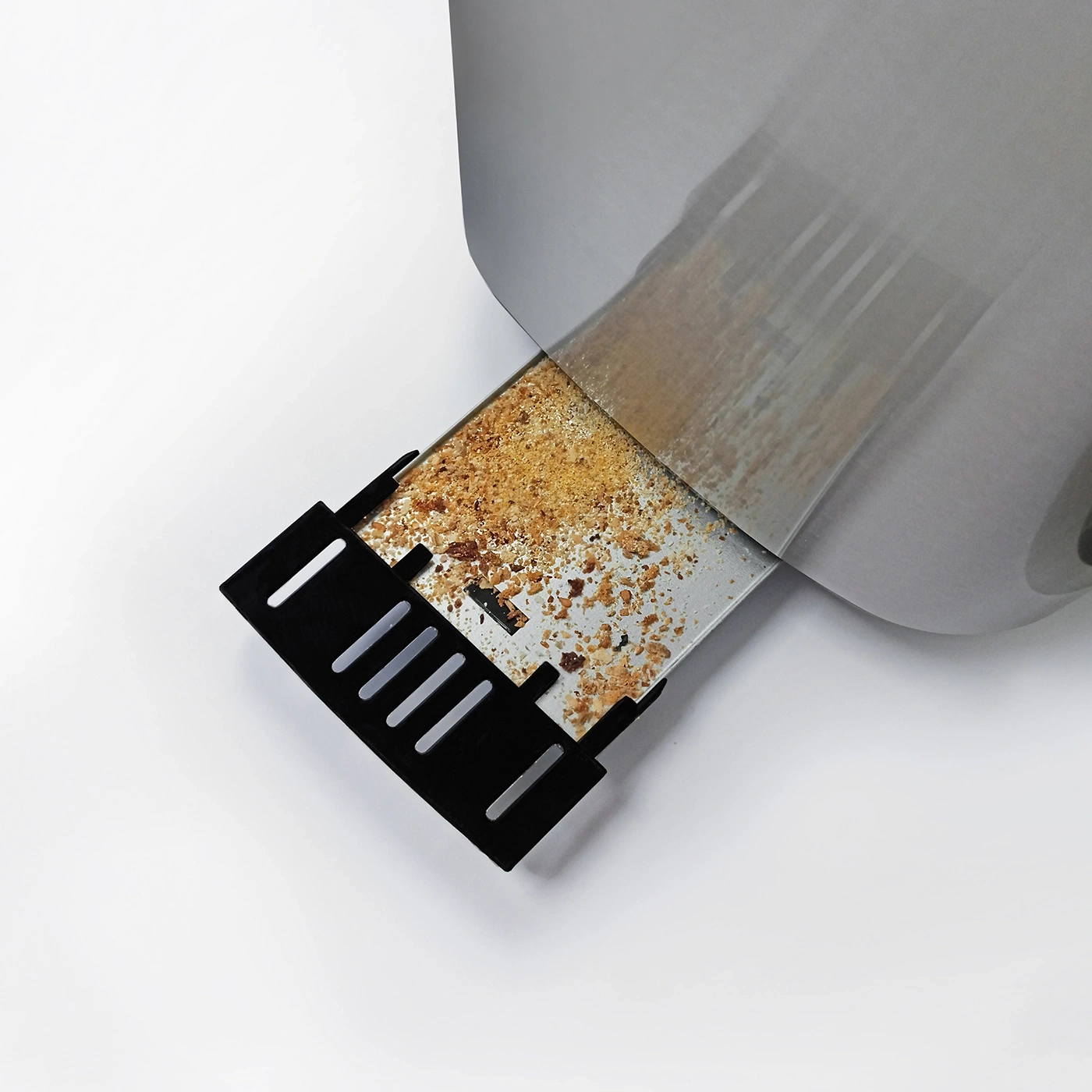 Nahaufnahme eines Toasters mit Krümeln und einem schwarzen Auffangbehälter.