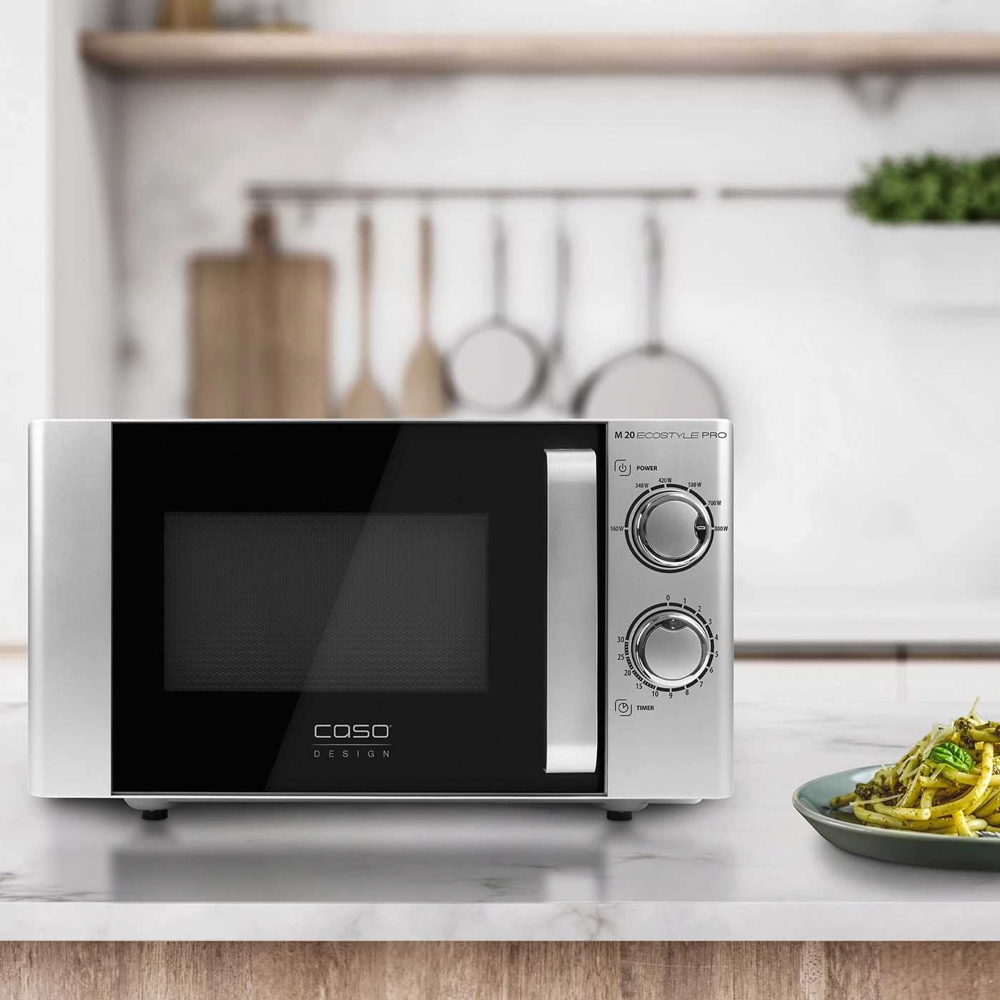 Caso Design M 20 microwave, silver, with cooking surface and pasta on a plate.