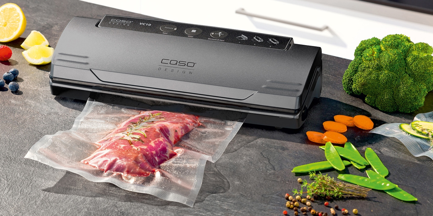 Vacuum sealer with meat and vegetables on a countertop