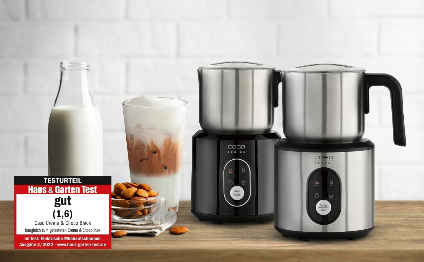 Milk frothers with rating, glass, milk bottle and almonds on wooden surface.