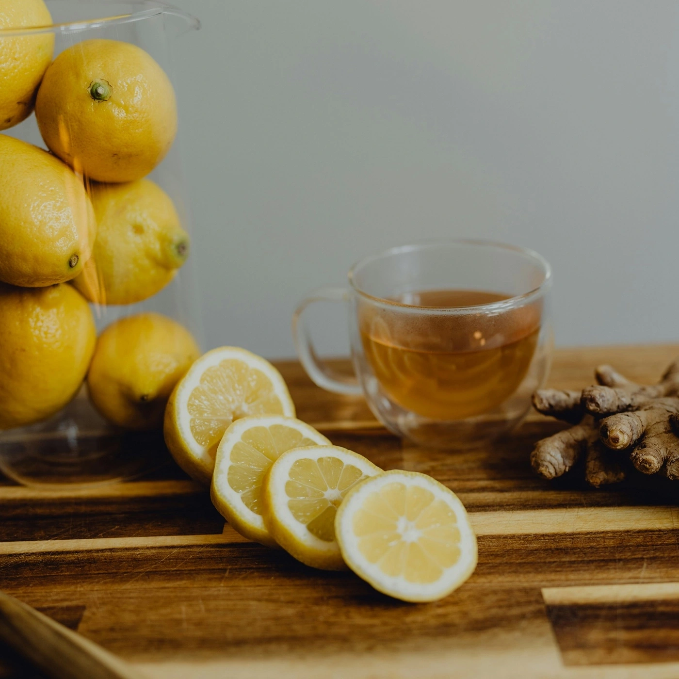 Lemon slices, tea, and ginger on a wooden board. Healthy drink.