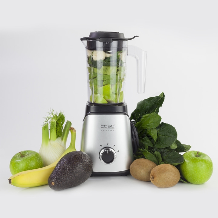 Ein Mixer mit Zutaten wie Äpfeln, Bananen, Kiwi und Spinat.