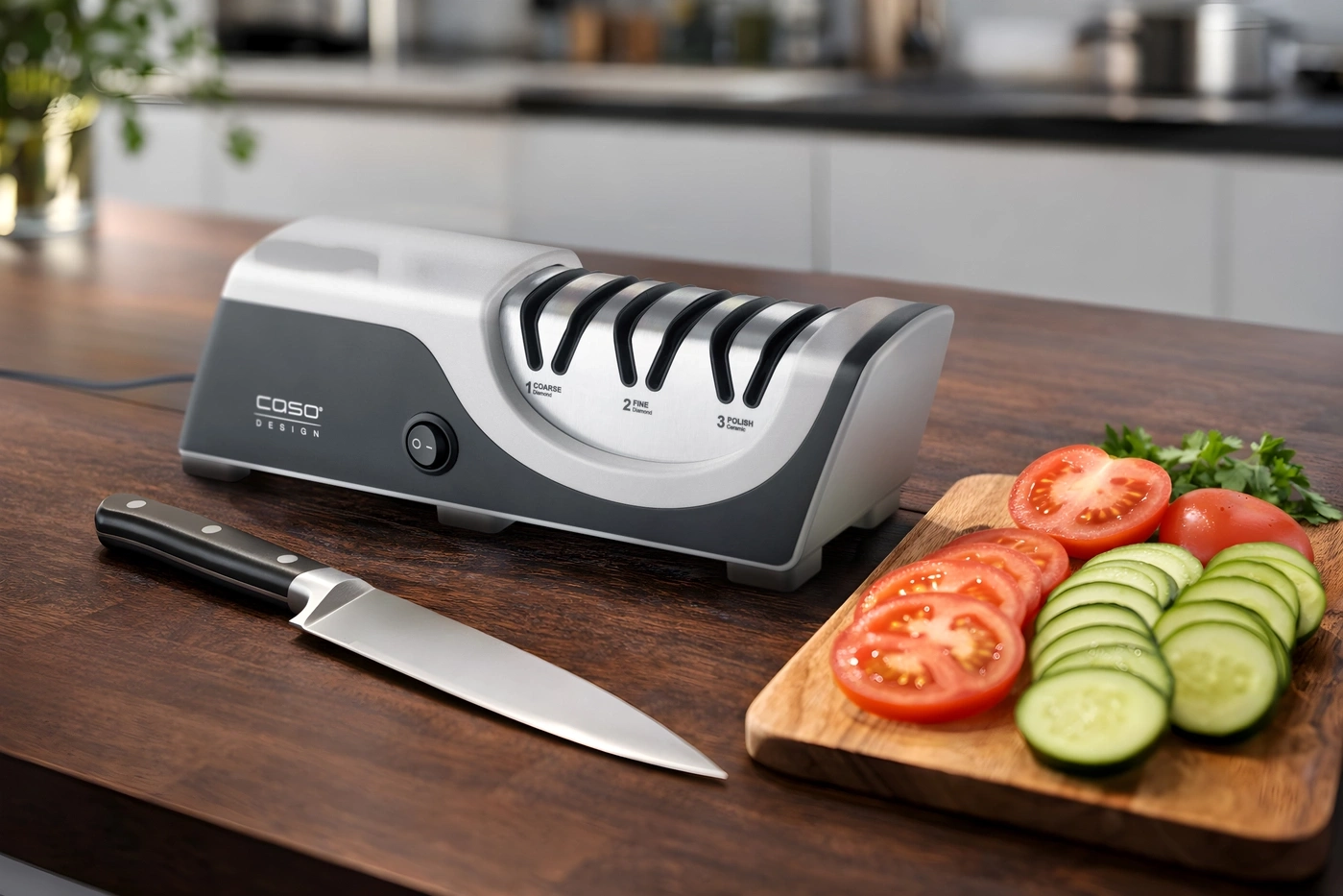 Messer schärfen mit CASO Design Schärfer, Tomaten und Gurken auf Holzbrett.