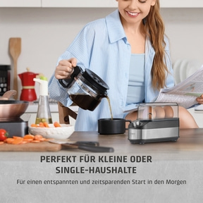 Frau gießt Kaffee ein, neben einem Eierkocher und Gemüse.