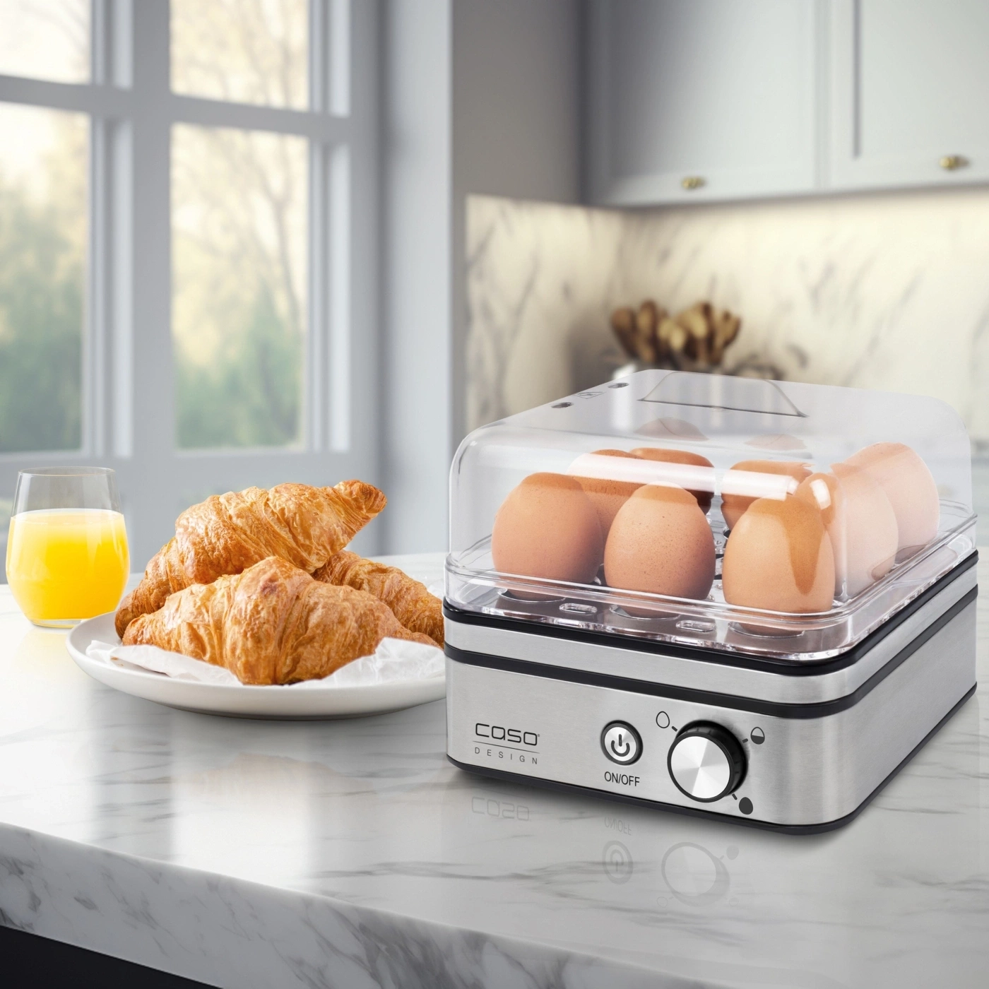 Ein Frühstück mit Croissants, Orangensaft und einem Eierkocher mit Eiern