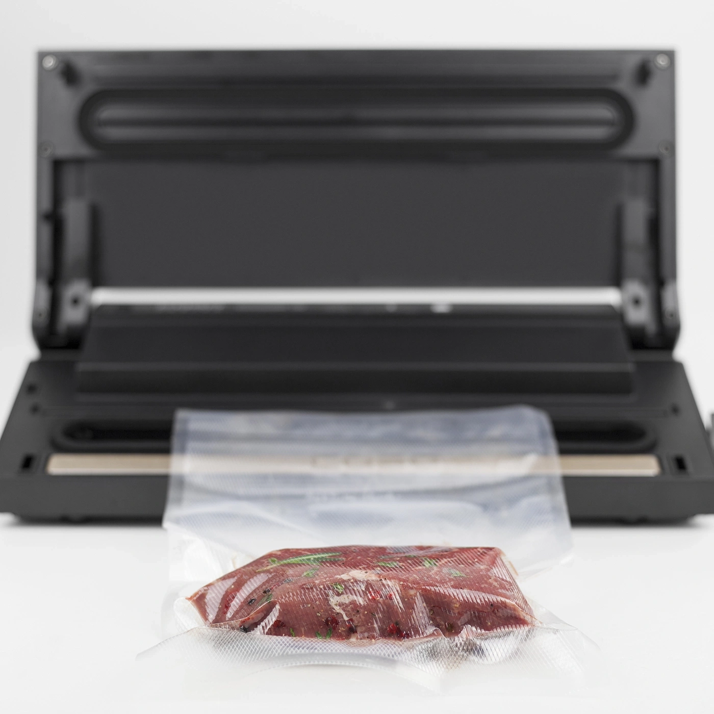 Meat in vacuum packaging in front of a vacuum sealer. Food preservation.
