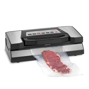 Vacuum sealer with meat in a plastic bag, ready for vacuum sealing process.