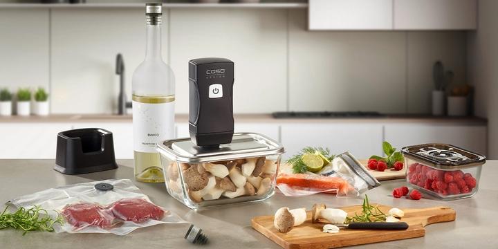 Kitchen scene with vacuum sealer, food items, and wine bottle