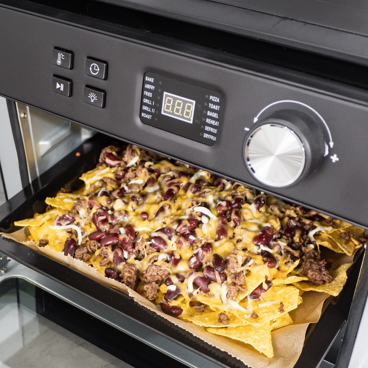 Ein Ofen mit Nachos, Käse, Bohnen und Fleisch. Backen, Grillen, Toasten.