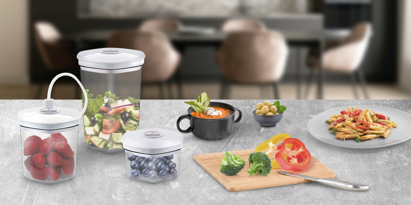 Vakuumbehälter mit Lebensmitteln, Gemüse, Obst und Mahlzeiten auf einem Tisch