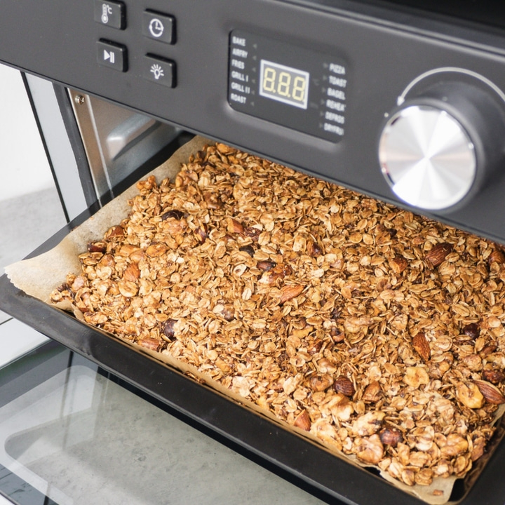 Granola in the oven. Baking tray with crunchy granola. Close-up shot.