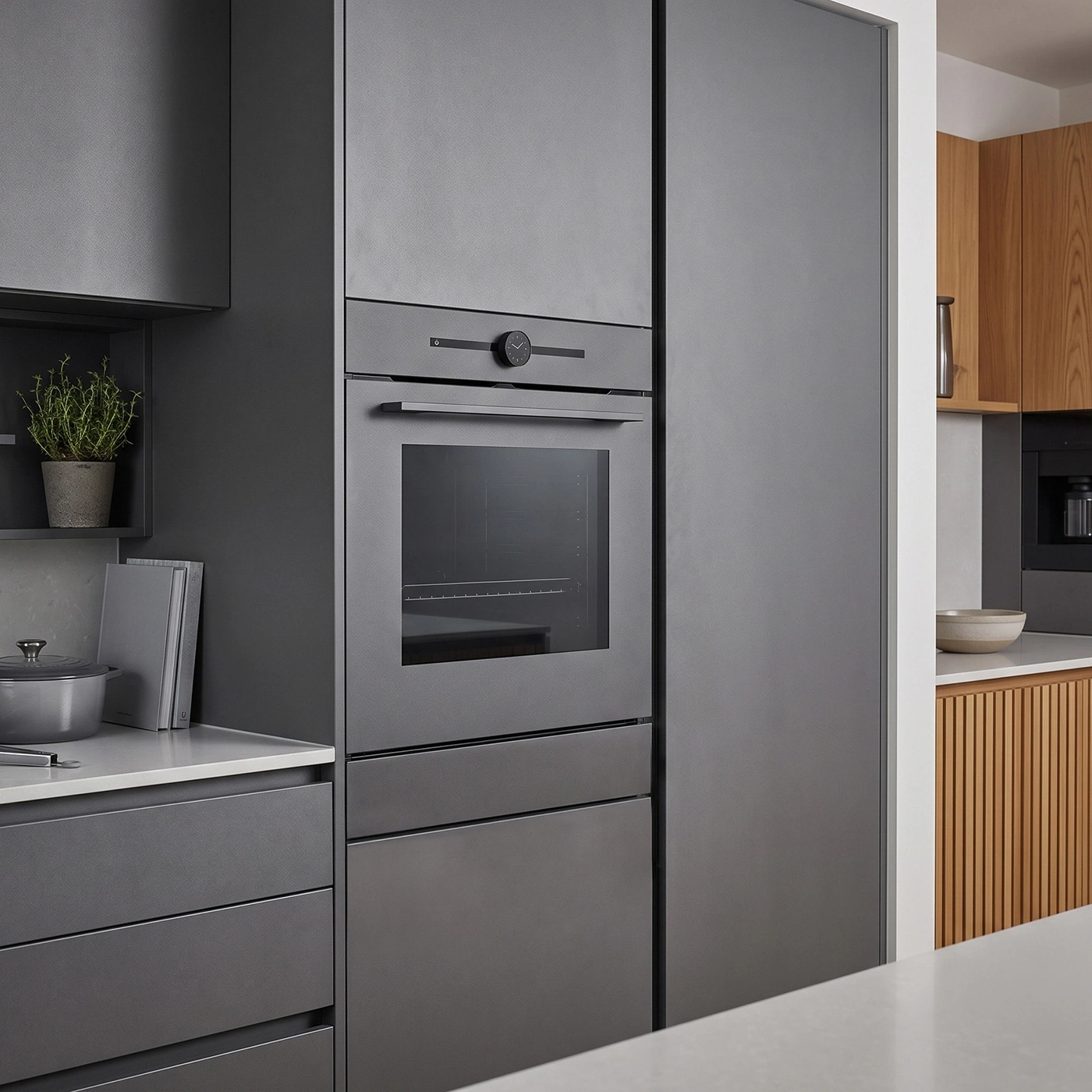 Modern gray kitchen with integrated oven and wood accents.