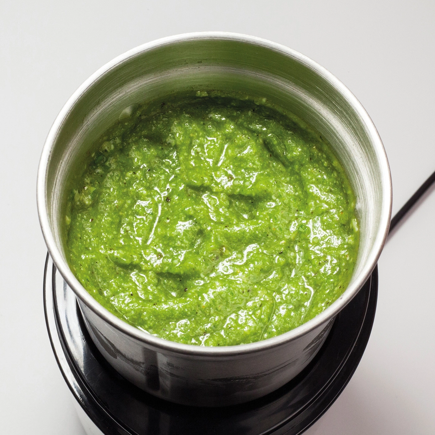 Grüne Sauce in einem Metallbehälter, Nahaufnahme, frisch zubereitetes Pesto