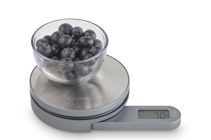 Blueberries in a glass bowl on a scale, displaying a weight of 70 grams.