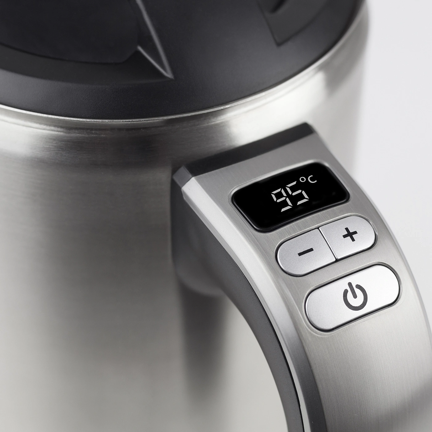 Close-up of a kettle with temperature display and control buttons.