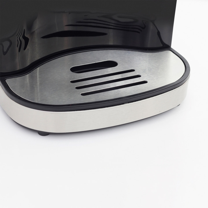 Close-up of a silver and black coffee machine with a drip tray