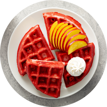Red waffles with peach slices and cream on a white plate