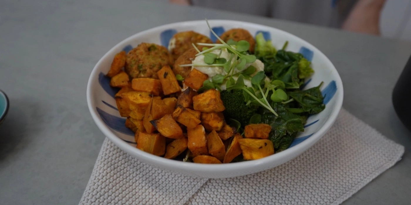 Eine Schüssel mit Süßkartoffeln, Falafel, Brokkoli und Spinat.