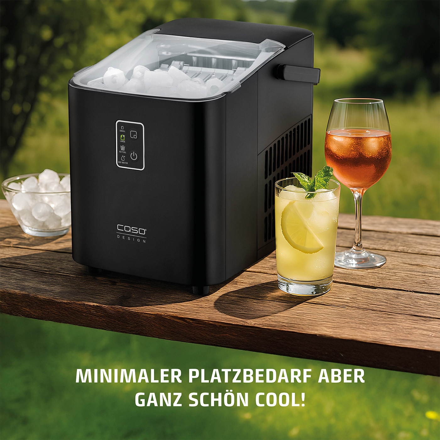 Eiswürfelmaschine mit Getränken auf einem Holztisch im Freien. Minimaler Platzbedarf.