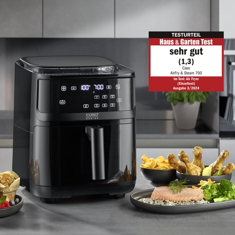 Schwarze Heißluftfritteuse mit Essen und Testurteil 'sehr gut'.
