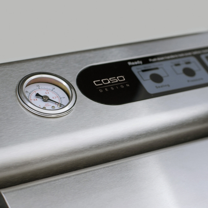 Close-up of a stainless steel vacuum sealer with a gauge and control panel.