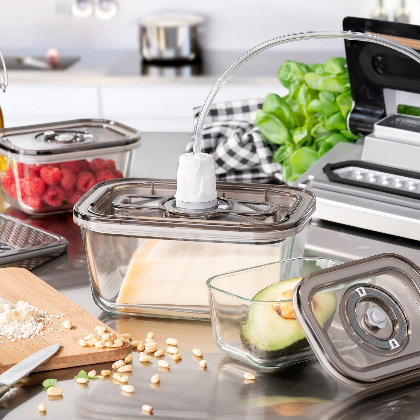 Vacuum containers with fresh food like berries, avocado, and cheese.