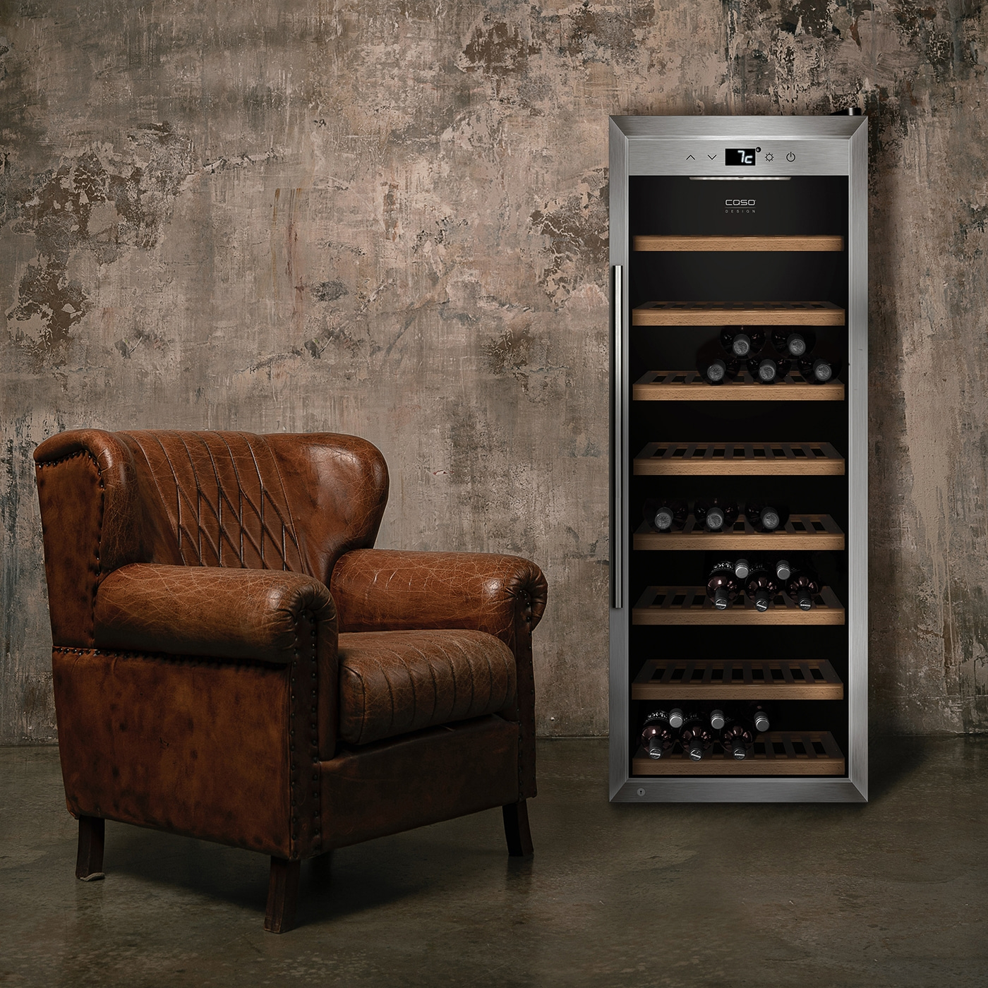 Leather armchair next to wine cooler with wine bottles in a room