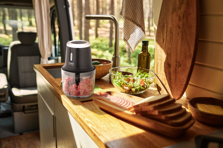 Kitchen scene with blender, salad, bread and ingredients in a campervan.