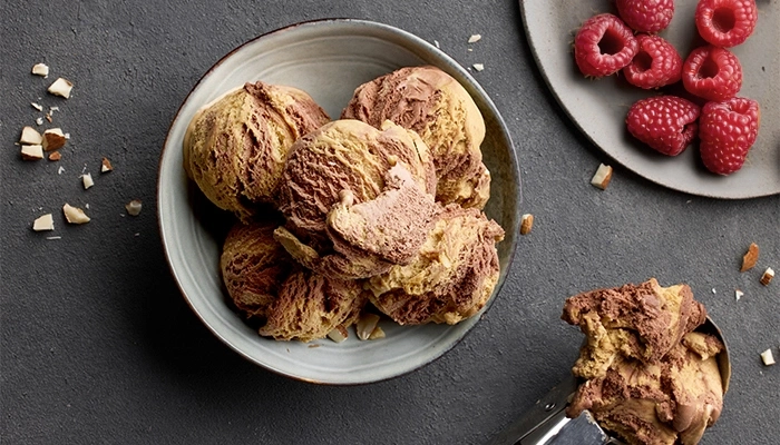 Ice cream with raspberries and almonds on a gray background