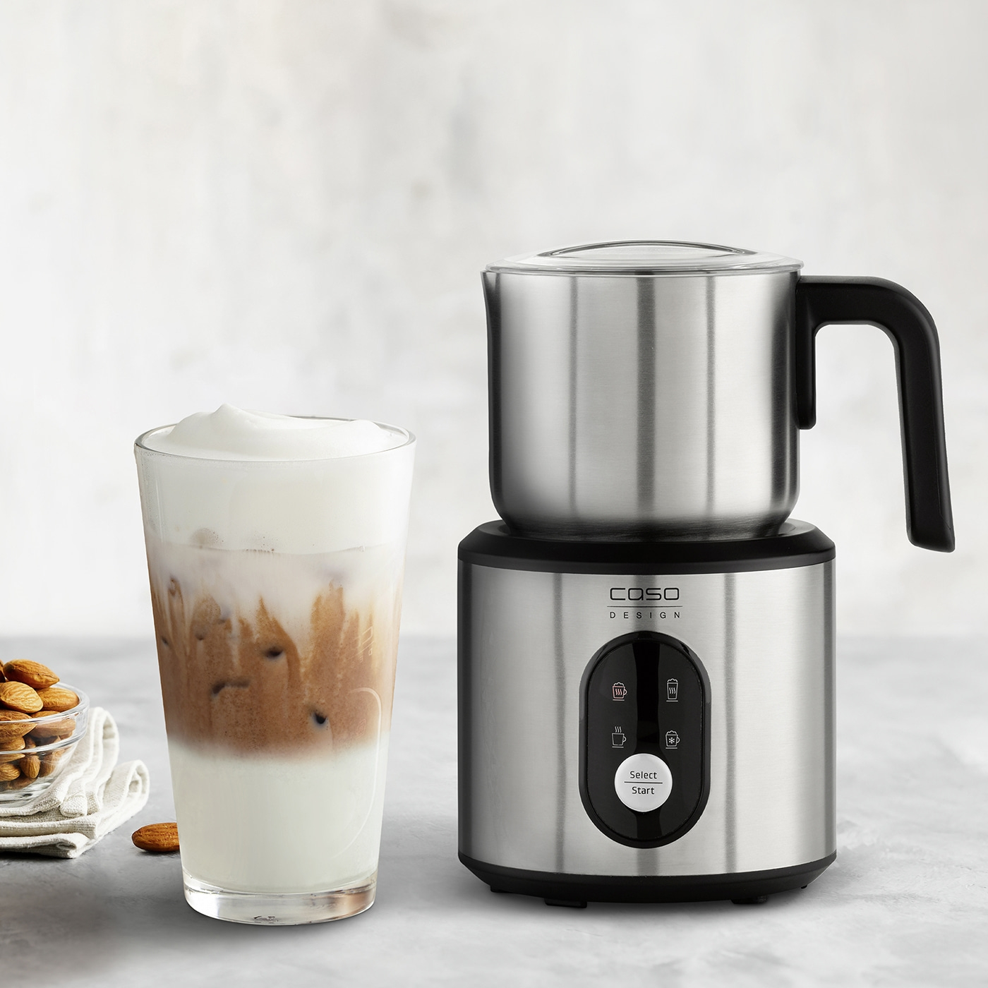 Milk frother with glass and almonds, for coffee preparation