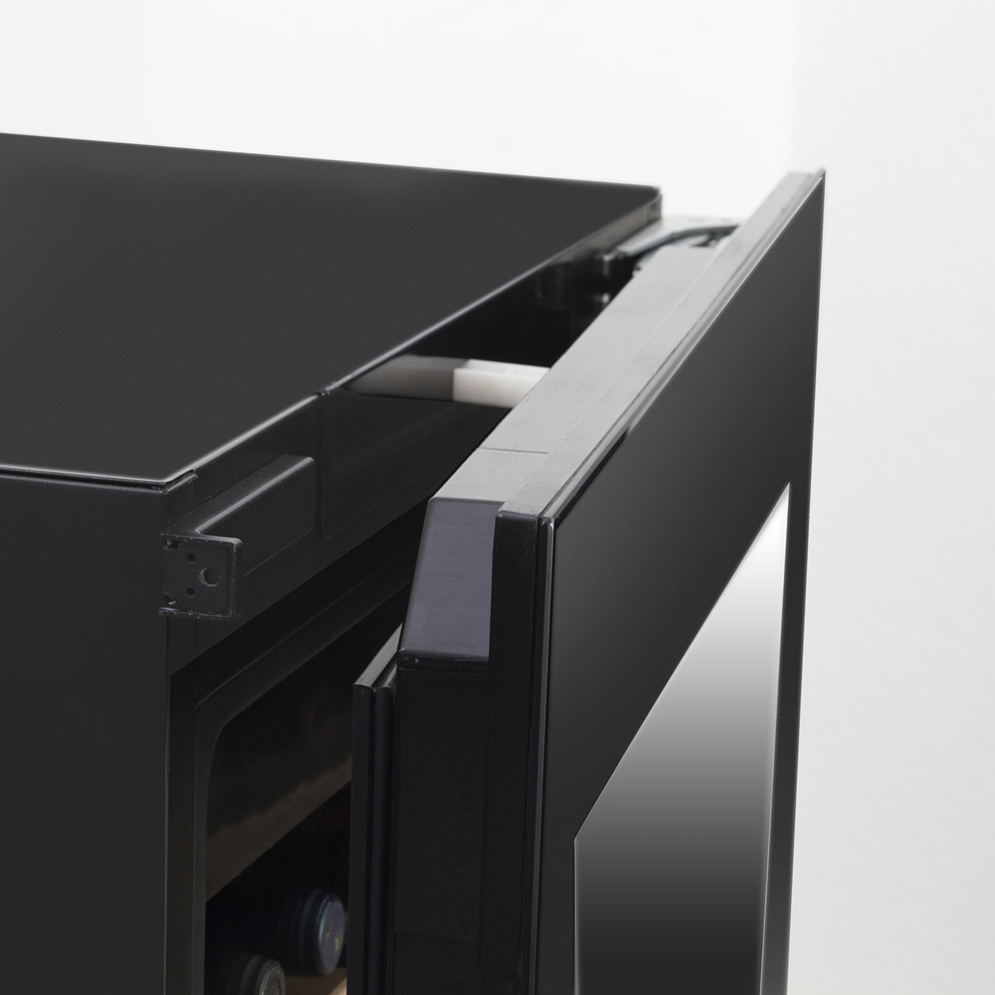 Black refrigerator with open door, detail shot, interior view, wine bottles inside