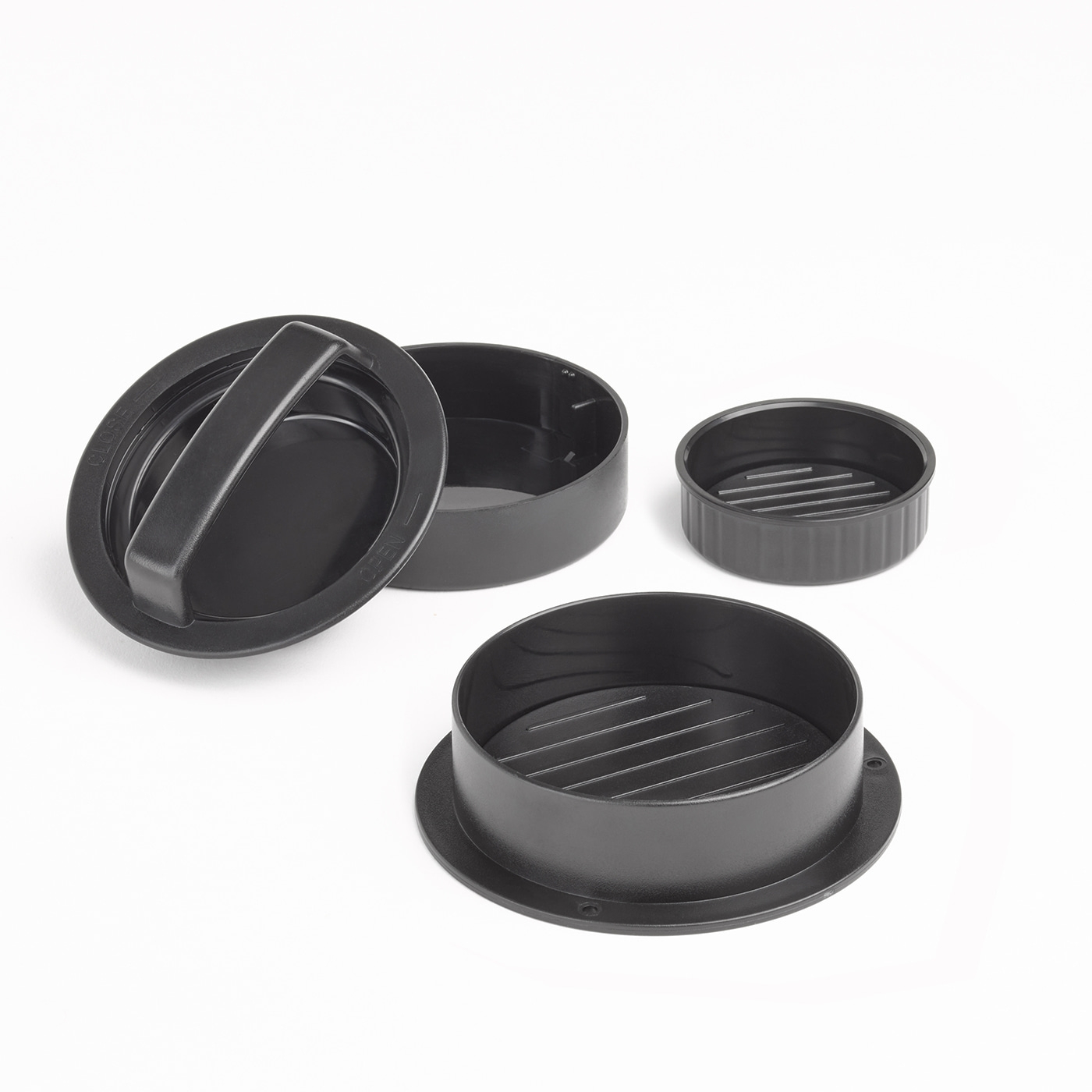 Black burger press disassembled on white background, close-up, kitchen tool