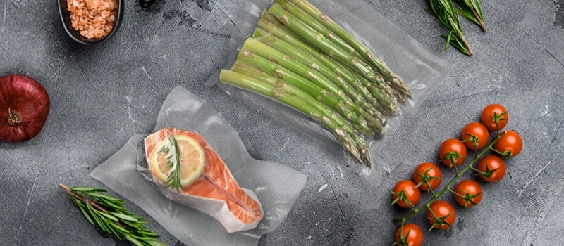 Salmon, asparagus, tomatoes, onion, rosemary, and salt on a gray surface