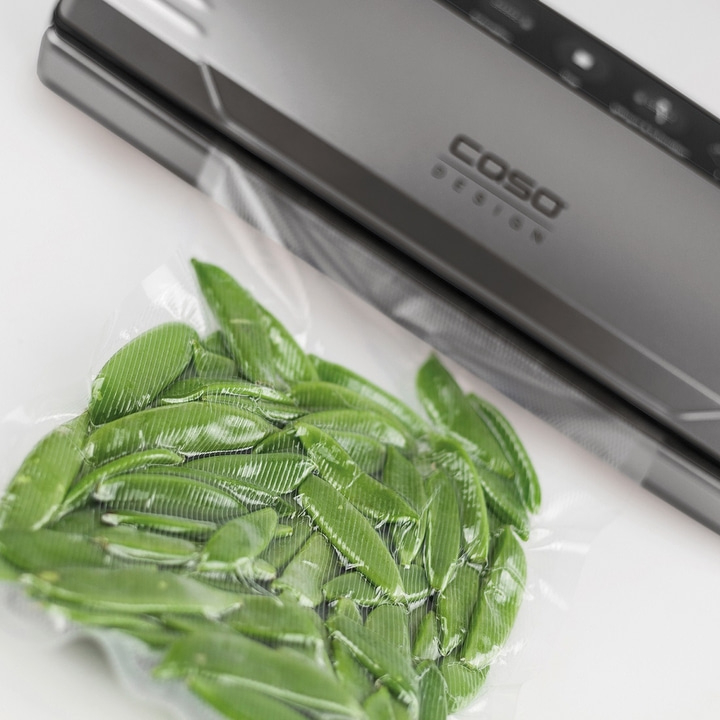 Peas in a vacuum pack next to a vacuum sealer, COSO Design logo visible.