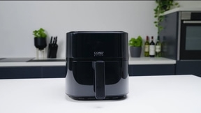 Schwarze Caso Design Heißluftfritteuse auf weißem Tisch in der Küche.