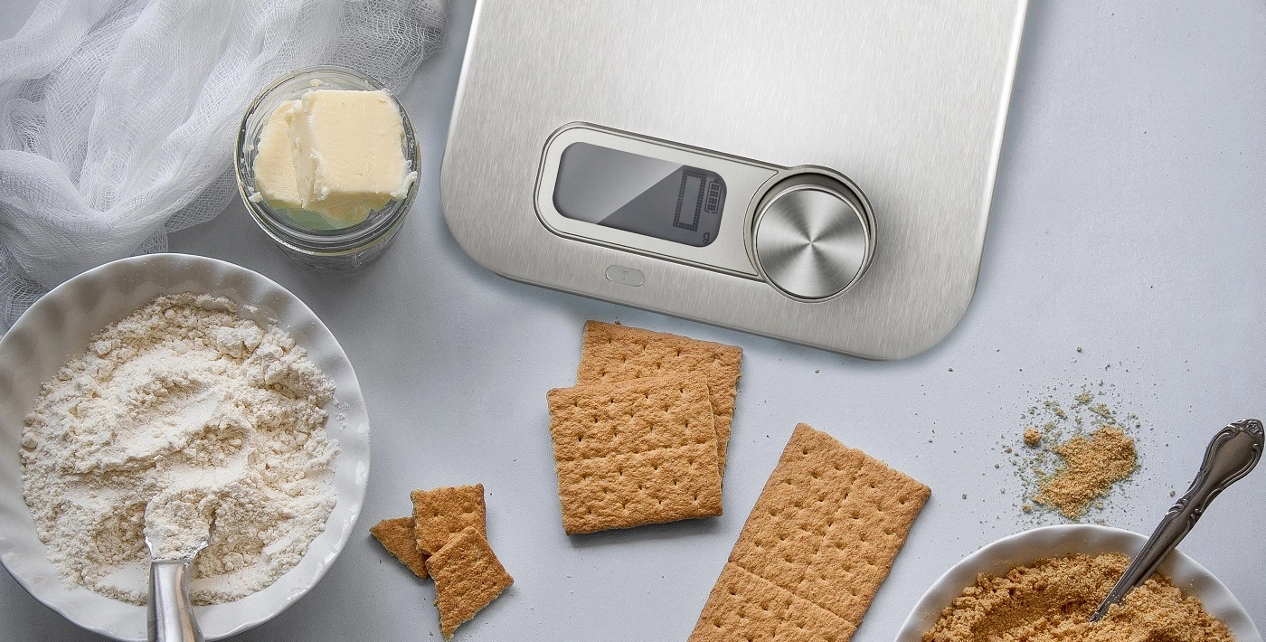 Ingredients for a cake: butter, flour, crackers, scale, bowl, spoon, food