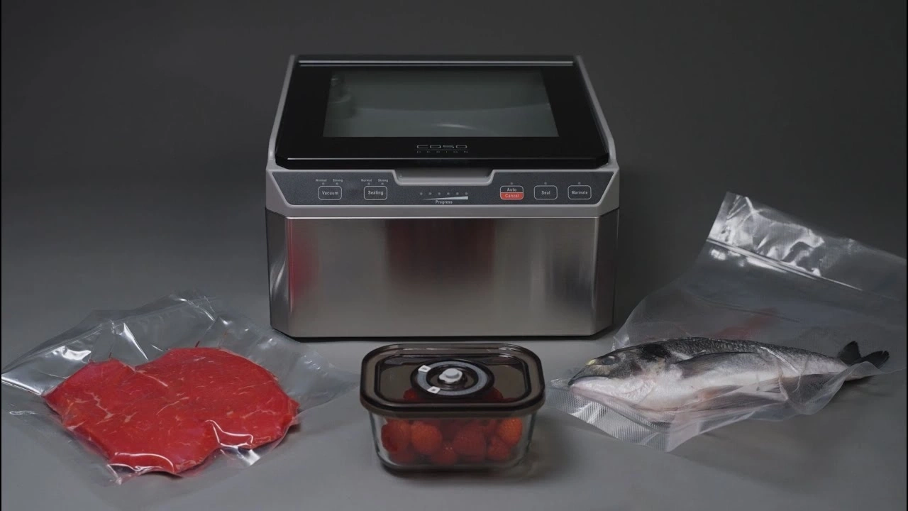 Vakuumiergerät mit Fleisch, Fisch und Erdbeeren in Beuteln und Behälter