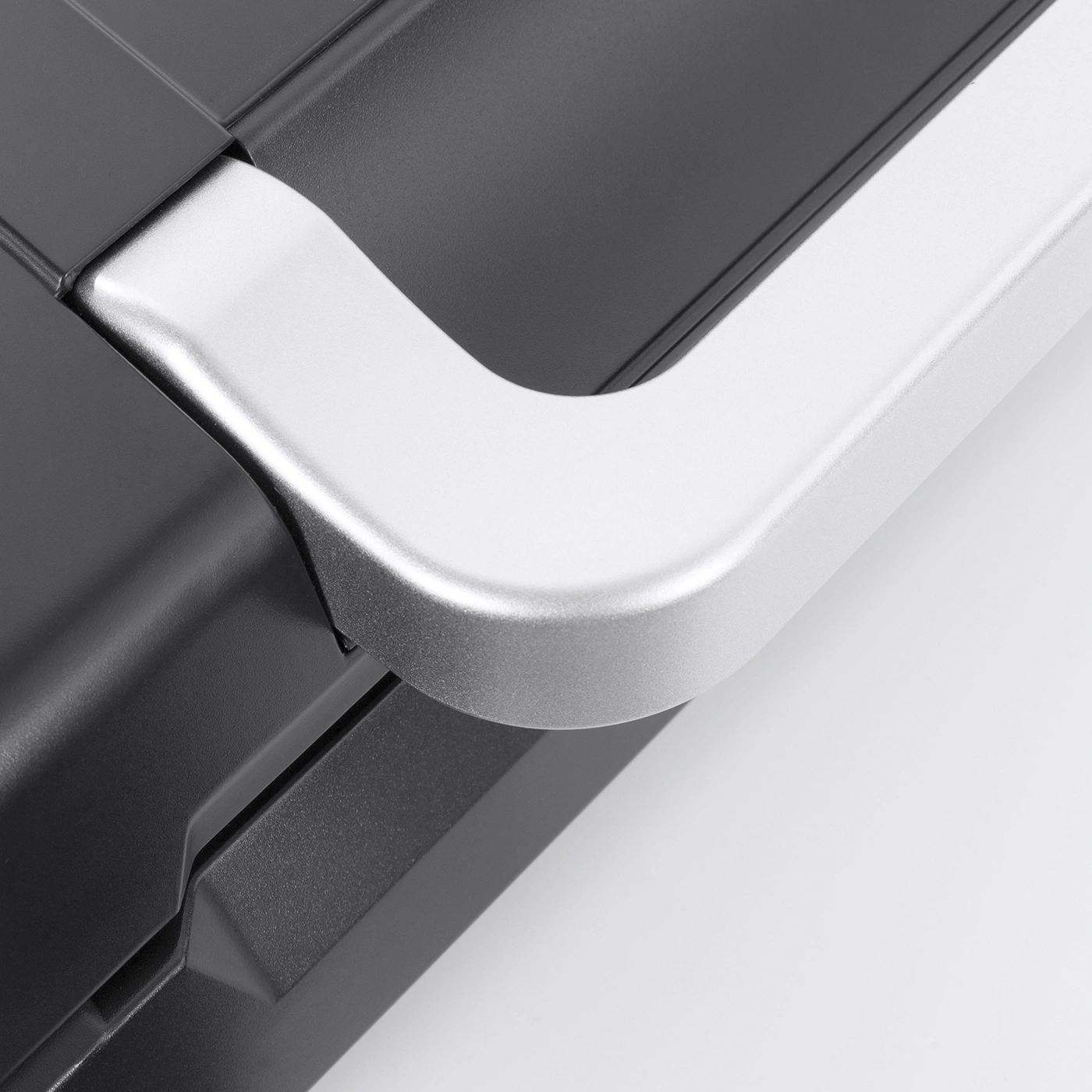 Close-up of a black appliance with a silver handle against a white background.