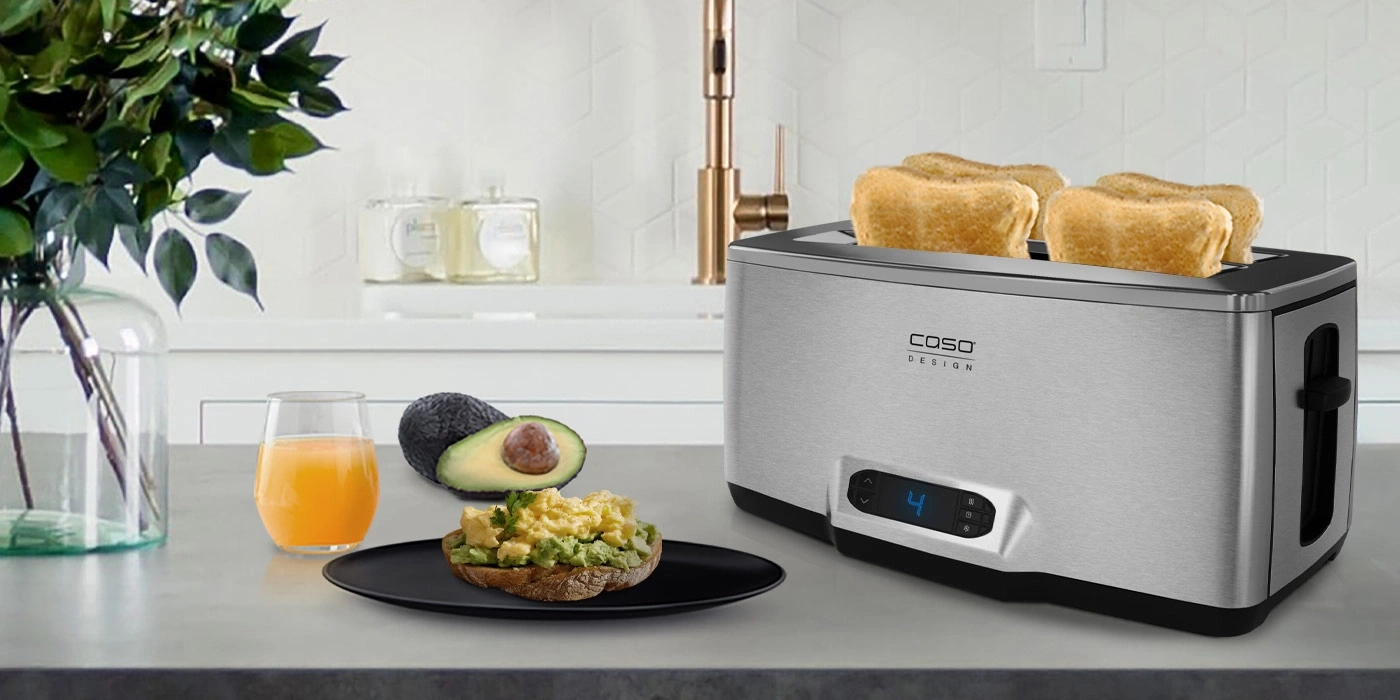 Frühstück mit Toast, Avocado und Saft neben einem Toaster in der Küche
